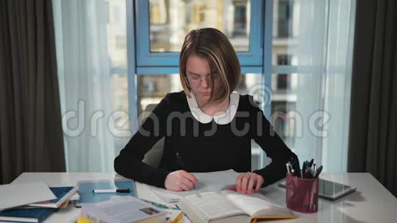 心烦意乱的女学生正在读一本书并在练习本中写作它会很沮丧会搞清楚视频的预览图
