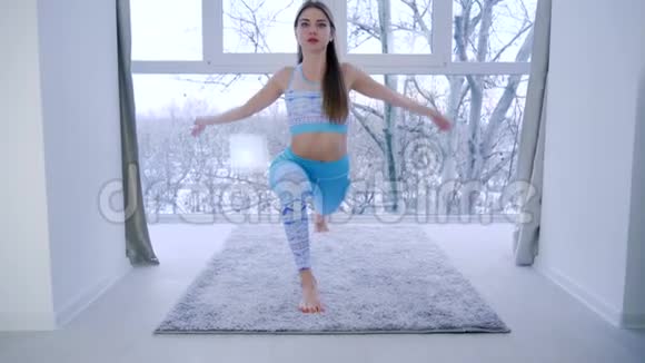 晨练瑜伽运动室内靠近窗户的健康女孩平衡视频的预览图