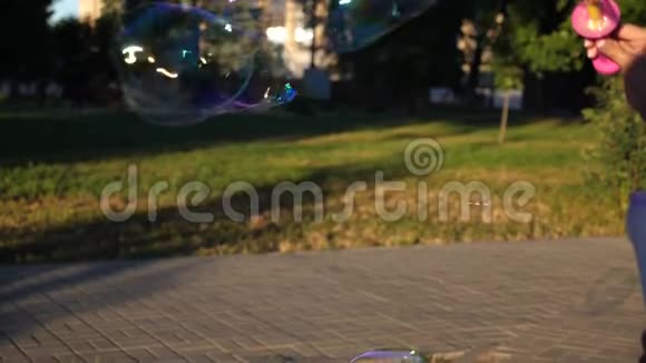 孩子让大泡泡在城市公园里特写镜头慢动作视频的预览图