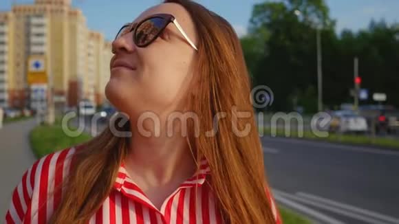 夏天穿红色衣服的年轻女孩的肖像幸福的年轻女子对着镜头微笑近距离射击视频的预览图