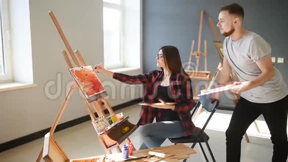 艺术家在画室里画画有创意的艺术家们设计了一幅彩色的油画画在画布上视频的预览图