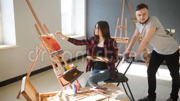 艺术家在画室里画画有创意的艺术家们设计了一幅彩色的油画画在画布上视频的预览图