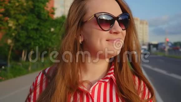 夏天穿红色衣服的年轻女孩的肖像幸福的年轻女子对着镜头微笑近距离射击视频的预览图