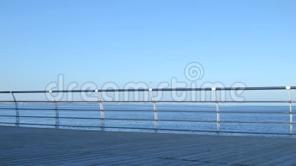 漂亮的女人在海边码头散步4K夏季时间宽框架视频的预览图
