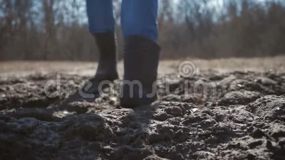 农夫带着橡胶靴沿着犁田走工作用橡胶靴1一个工人带着他的孩子下了一堆土视频的预览图