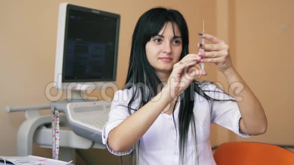 慢镜头拍摄年轻的女性黑发医生拿着注射器用它来准备注射视频的预览图