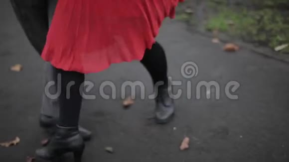 男人女人在铺满黄叶的小路上跳舞视频的预览图