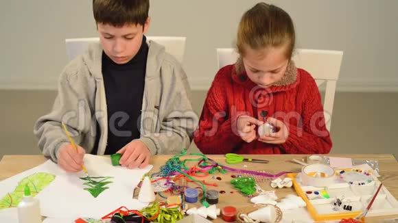 儿童为节日做装饰工艺品和玩具圣诞树等画水彩上景艺术作品视频的预览图