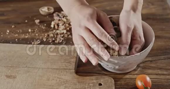 女人从陶瓷碗里拿出鹌鹑蛋放在木板上背景与天然沙拉原料视频的预览图