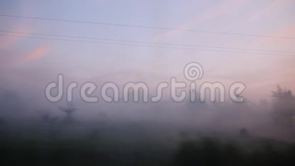 从火车窗口观看雾中的森林和山谷日出前的清晨视频的预览图