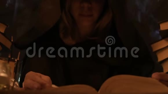 在一个黑暗的房间里在烛光下戴着帽子的女魔术师在念咒语低键带电摄像机神秘小型自由度视频的预览图