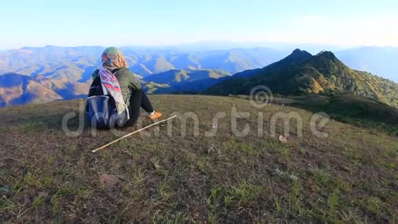 女徒步旅行者坐在泰国北部梅洪桑省的多皮最高山峰上视频的预览图