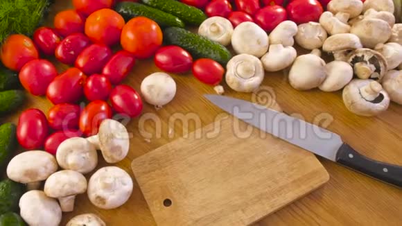 木板上有刀和新鲜蔬菜西红柿黄瓜西葫芦辣椒青菜萝卜蘑菇视频的预览图
