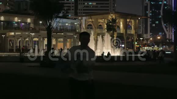 父女俩在夜城的背景下玩耍美丽的喷泉景色视频的预览图