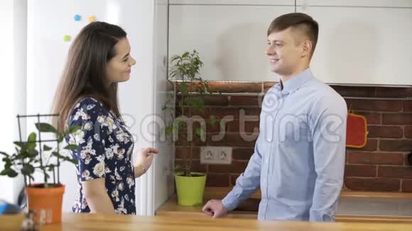 可爱又深情的年轻夫妇在厨房聊天视频的预览图