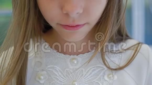 可爱的小女孩带着野花皇冠看着镜头眨巴视频的预览图