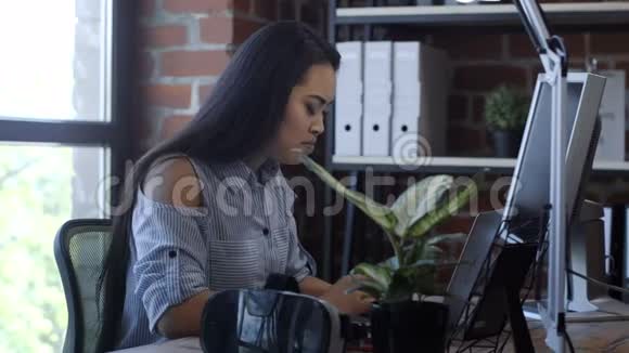 在电脑桌上工作的漂亮的种族女孩视频的预览图