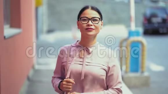 亚洲女商人微笑着走在街上视频的预览图