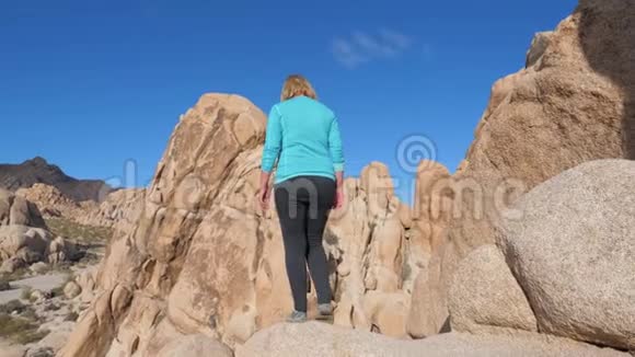 站在悬崖边上的肖像女子举起双手向侧面展开视频的预览图