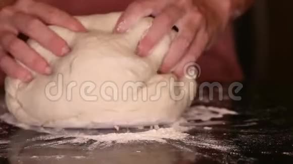 一个年轻的女人用手捏一团面包面团视频的预览图