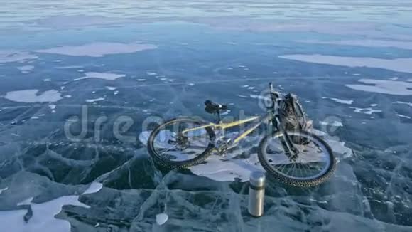 人和他的自行车在冰上他看着裂缝里美丽的冰第一人称观点骑自行车的人穿着视频的预览图