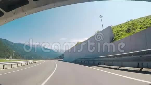 从一条高速公路行驶的汽车上可以看到一条路一侧是白色的石头屏障蓝色的清澈视频的预览图