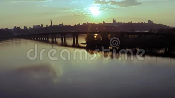 在春天日落之前在基辅的Dnieper河上俯瞰大桥的空中景色视频的预览图