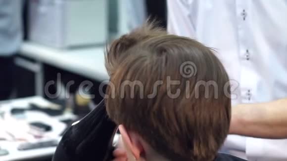 理发师用吹风机把孩子头发擦干视频的预览图