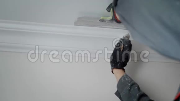 一个建筑工人的手被近距离射击一个在公寓里做修理的人人们在天花板上用一个造型画一个刷子视频的预览图