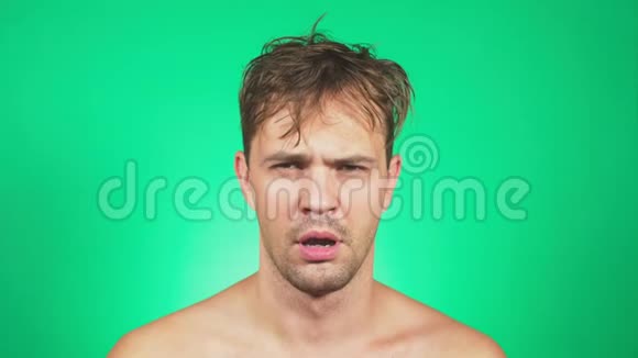 昏昏欲睡衣衫褴褛的年轻人赤裸的躯干打着哈欠看着镜头4k绿色背景慢动作视频的预览图
