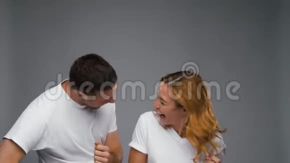 快乐的夫妻在灰色背景下跳舞视频的预览图