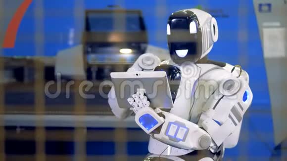 类似人类的机器人正在用平板电脑控制机械化设备视频的预览图