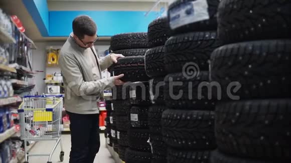 在汽车商店选择冬季轮胎的男人视频的预览图