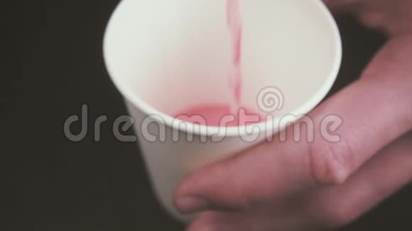 慢动作一杯红饮料倒在桌子上的玻璃杯里视频的预览图