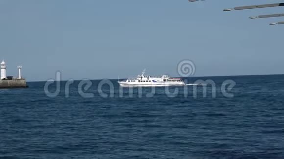 一艘白色游船返回码头经过灯塔视频的预览图