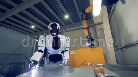 金属板正由一个机器人在一个现代化的工厂里焊接视频的预览图