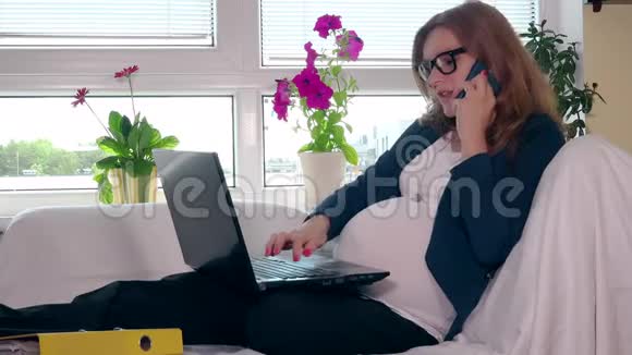 漂亮的年轻孕妇在家工作打电话的女性视频的预览图