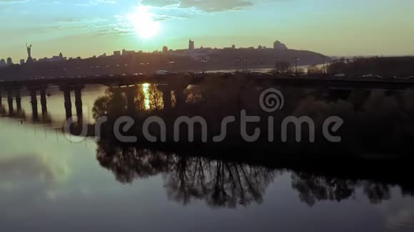在春天日落之前在基辅的Dnieper河上俯瞰大桥的空中景色视频的预览图