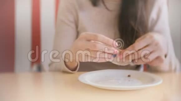 女人吃松饼用餐巾擦手放在盘子里视频的预览图