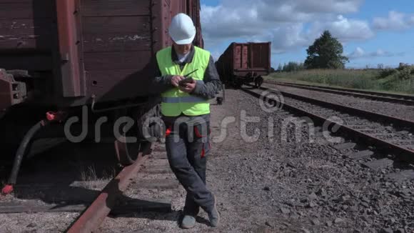 铁路员工在对讲机和平板电脑附近的货车视频的预览图