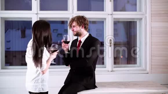 浪漫的夫妇喝红酒漂亮的年轻夫妇带着一杯红酒年轻浪漫情侣庆祝视频的预览图