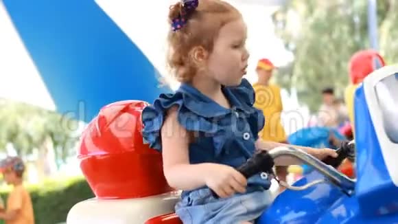 小女孩和骑电动摩托车在公园娱乐视频的预览图