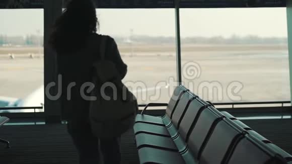 带着背包的女孩在等航班视频的预览图