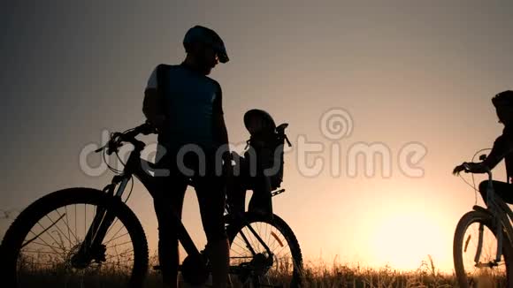 在太阳升起的背景下一对已婚夫妇骑自行车骑自行车视频的预览图