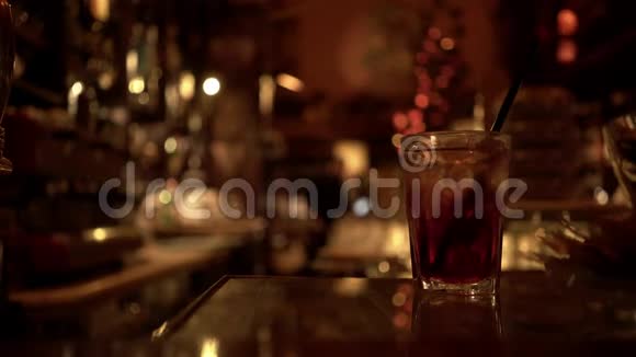 酒吧桌上的一杯酒精饮料背景模糊视频的预览图