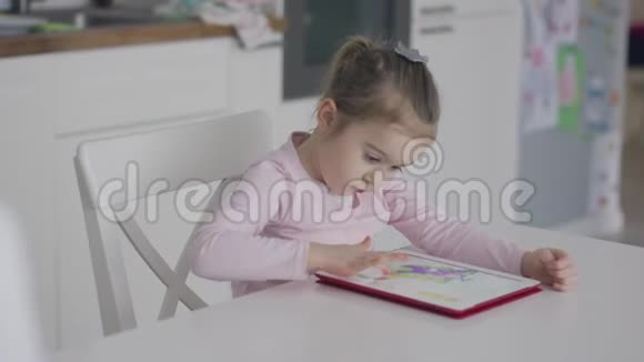 专注的女孩在平板电脑上玩游戏视频的预览图