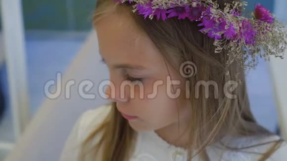 可爱的小女孩带着野花皇冠站在镜头4K视频的预览图
