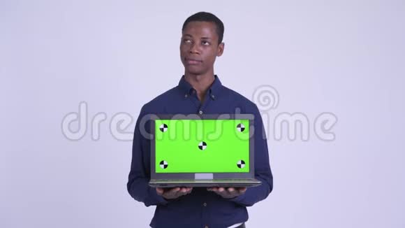 年轻快乐的非洲商人一边思考一边展示笔记本电脑视频的预览图