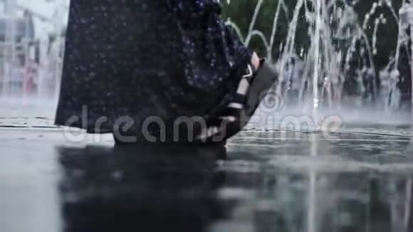 一个夏天的晚上女性的双脚站在地板上的喷雾之间视频的预览图