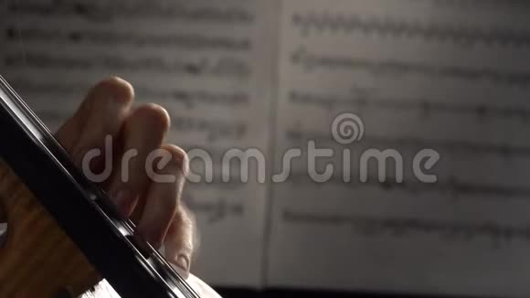 手指在背景片中用音符演奏大提琴的弦快关门侧视图视频的预览图